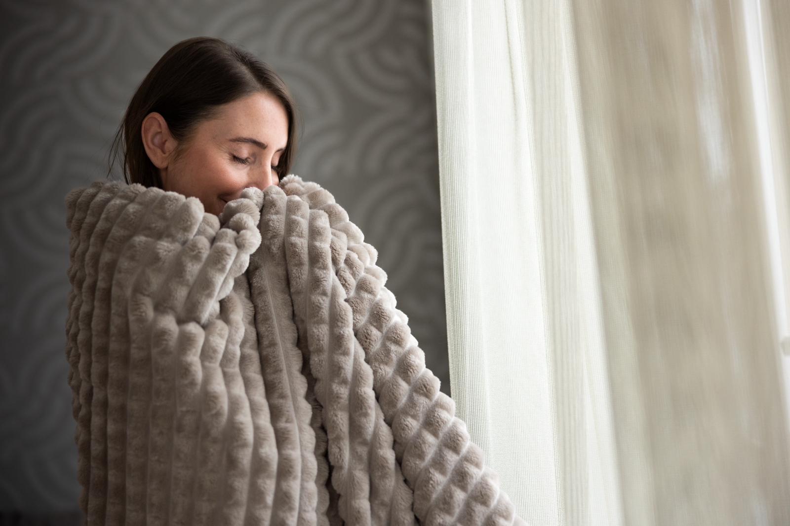 Frau kuschelt sich in eine Wenatex Kuscheldecke